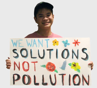 Student with sign: we want solutions not pollution.